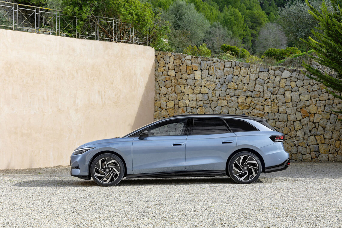 Modrý Volkswagen ID.7 Tourer zboku pri kamennom múre. Ilustračná fotografia: Volkswagen AG.